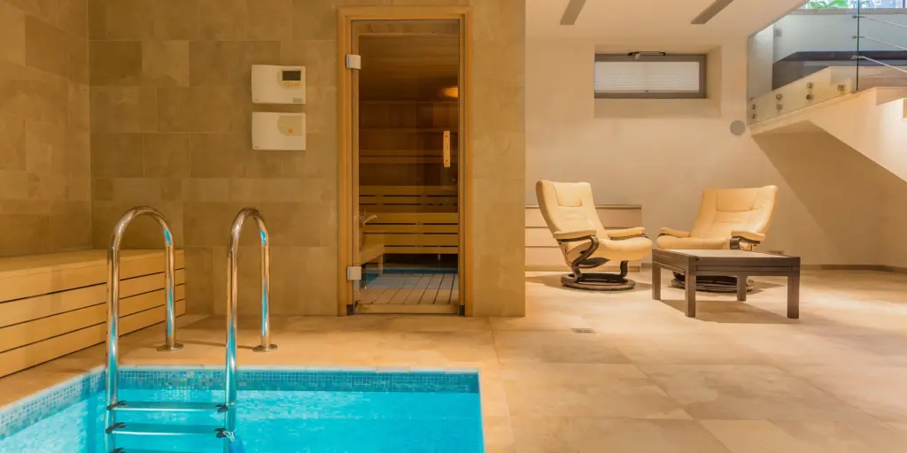 Moderner Spa-Bereich mit Pool, Sauna und bequemen Sitzgelegenheiten für entspannende Erholung.